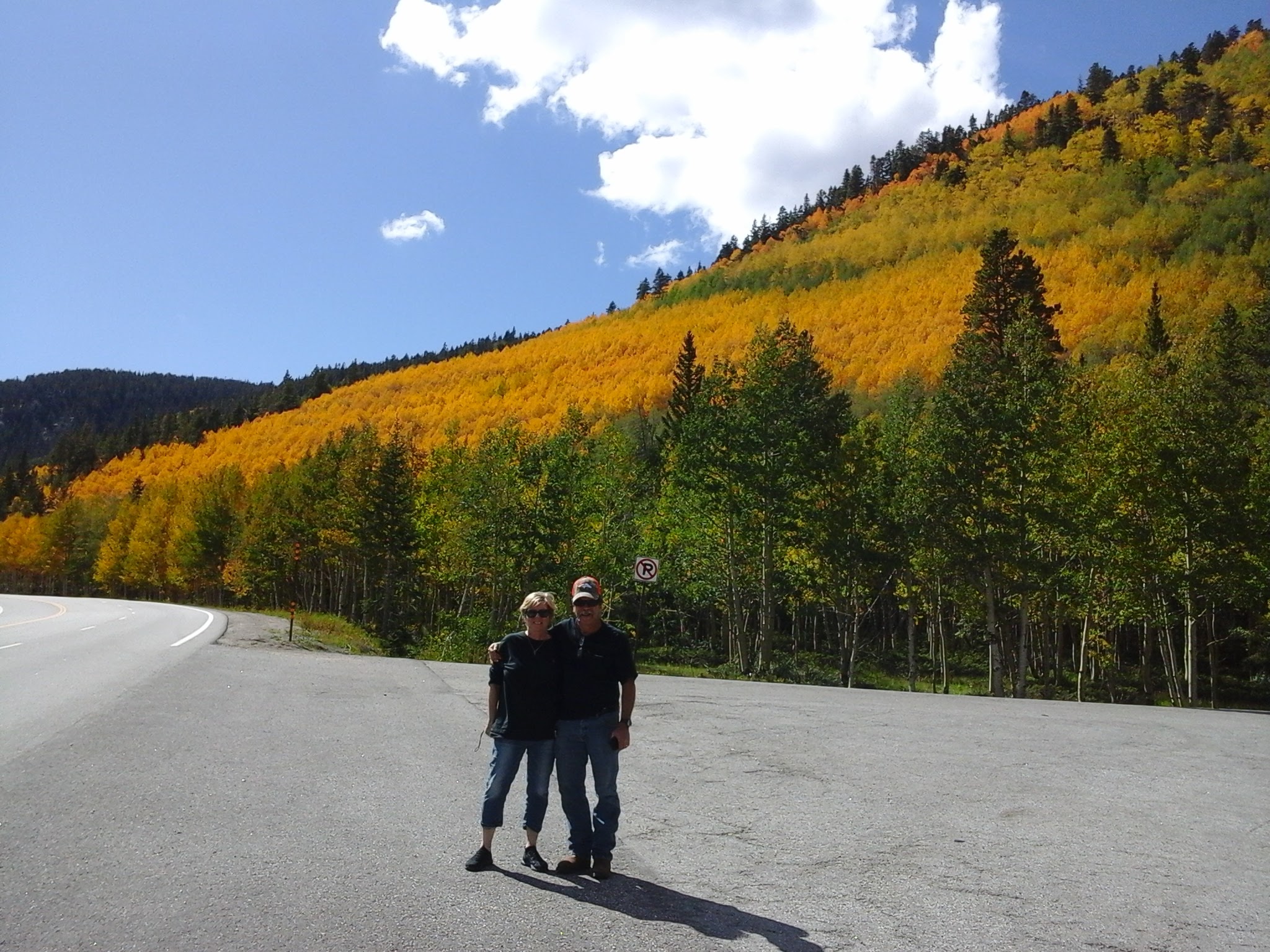 The peak of the fall colors along Monarch Pass with 2 people posing for a photo.