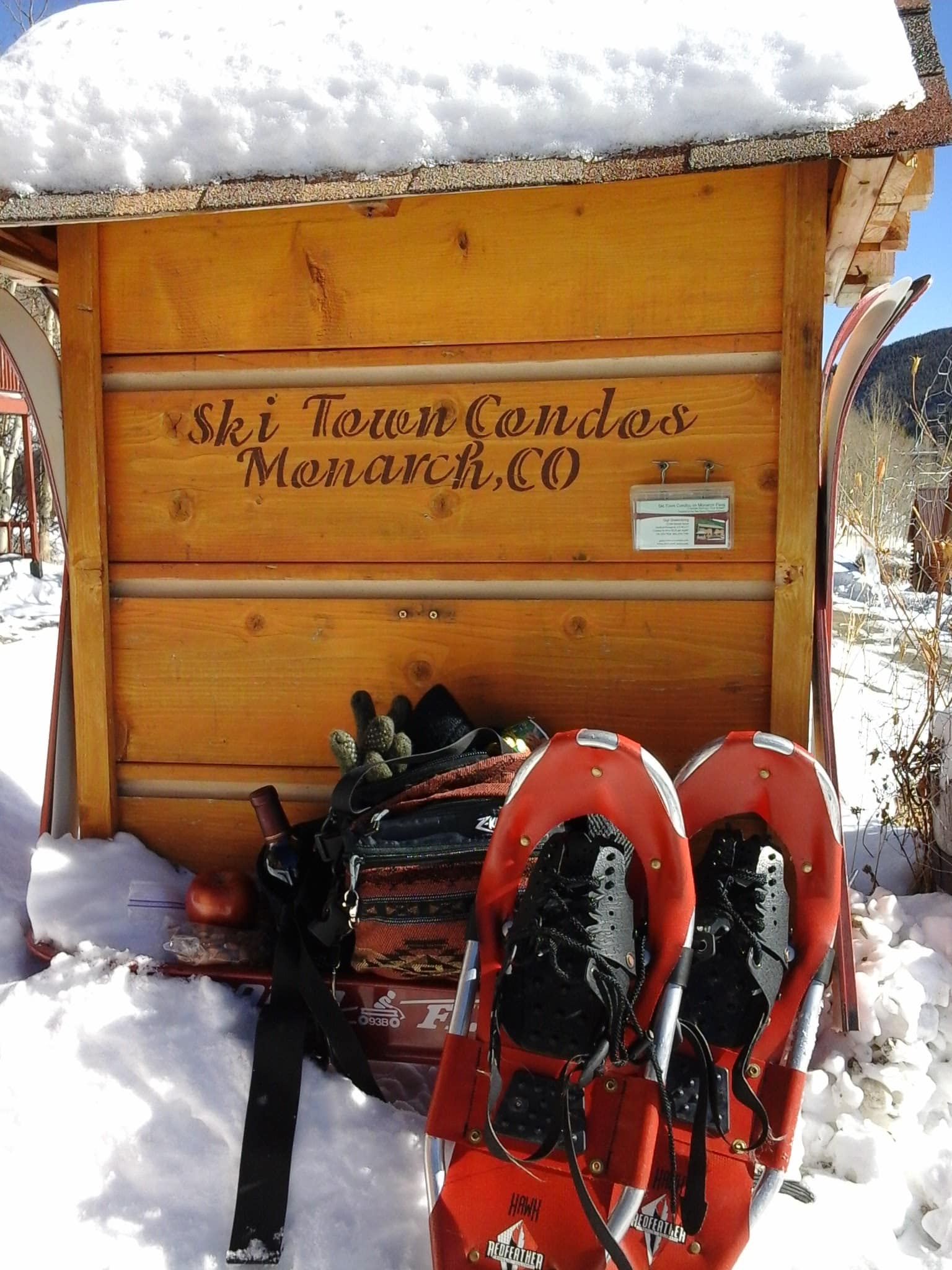 Set of snowshoes and pack leaning up against Ski Town Condos sign.