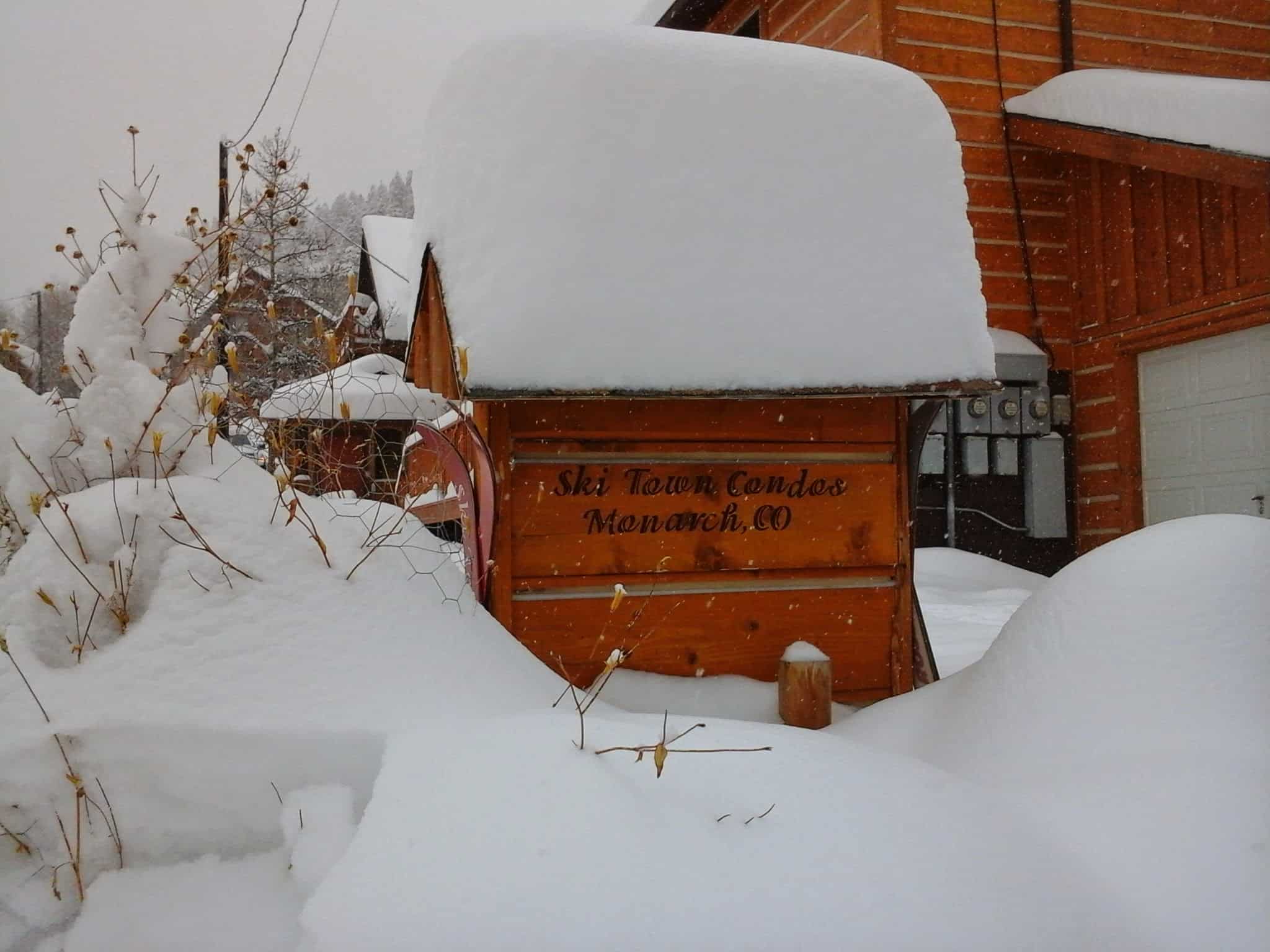 Snow piled high around Ski Town Condos sign.