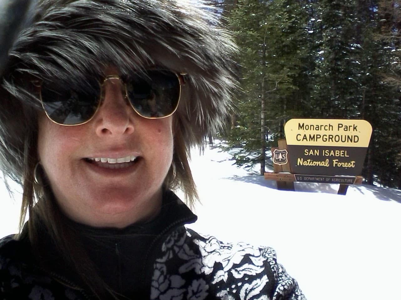 Cross country skiier with a fur mink hat enjoying the spring weather.