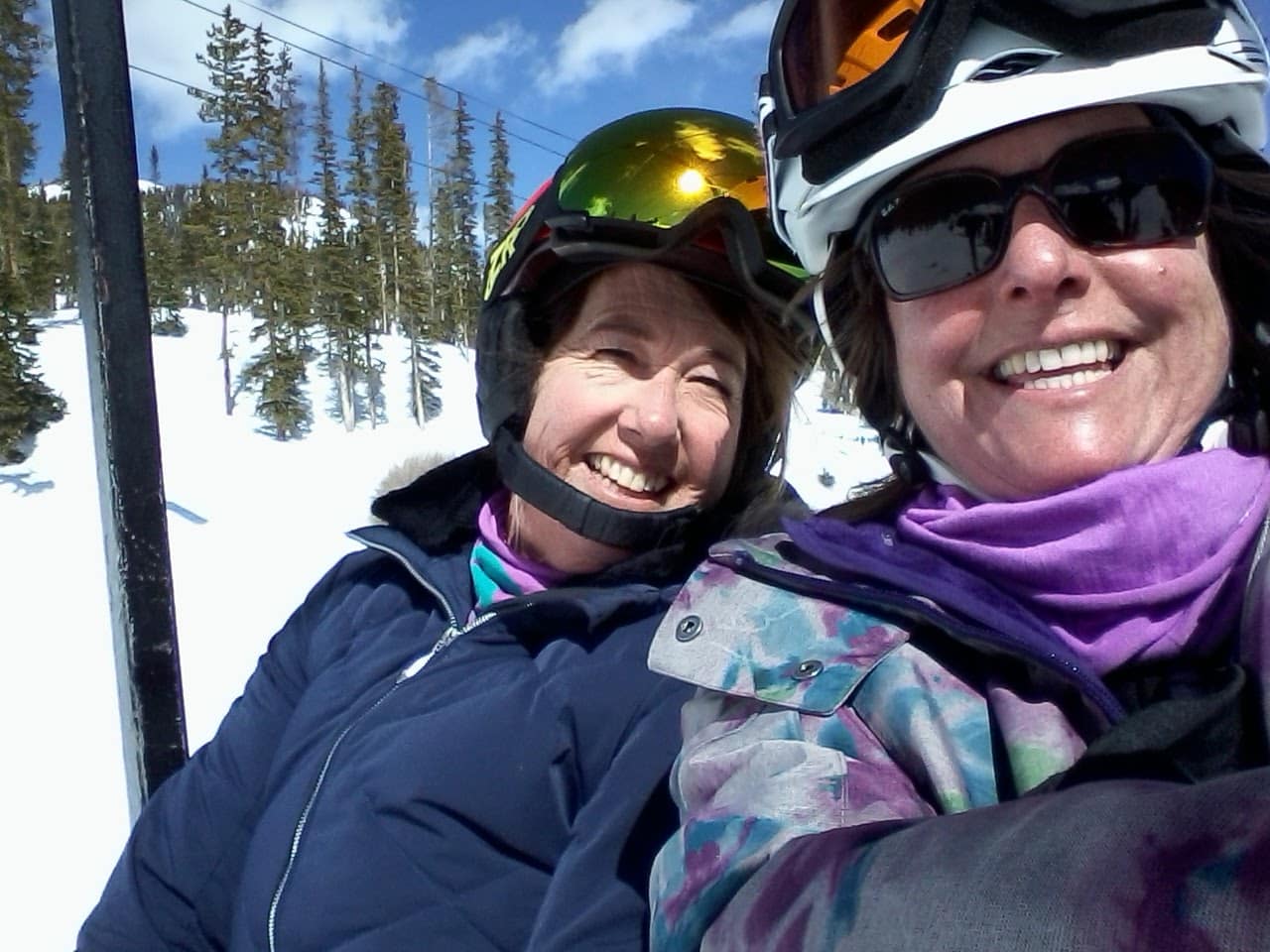 Two ladies on a chair lift.