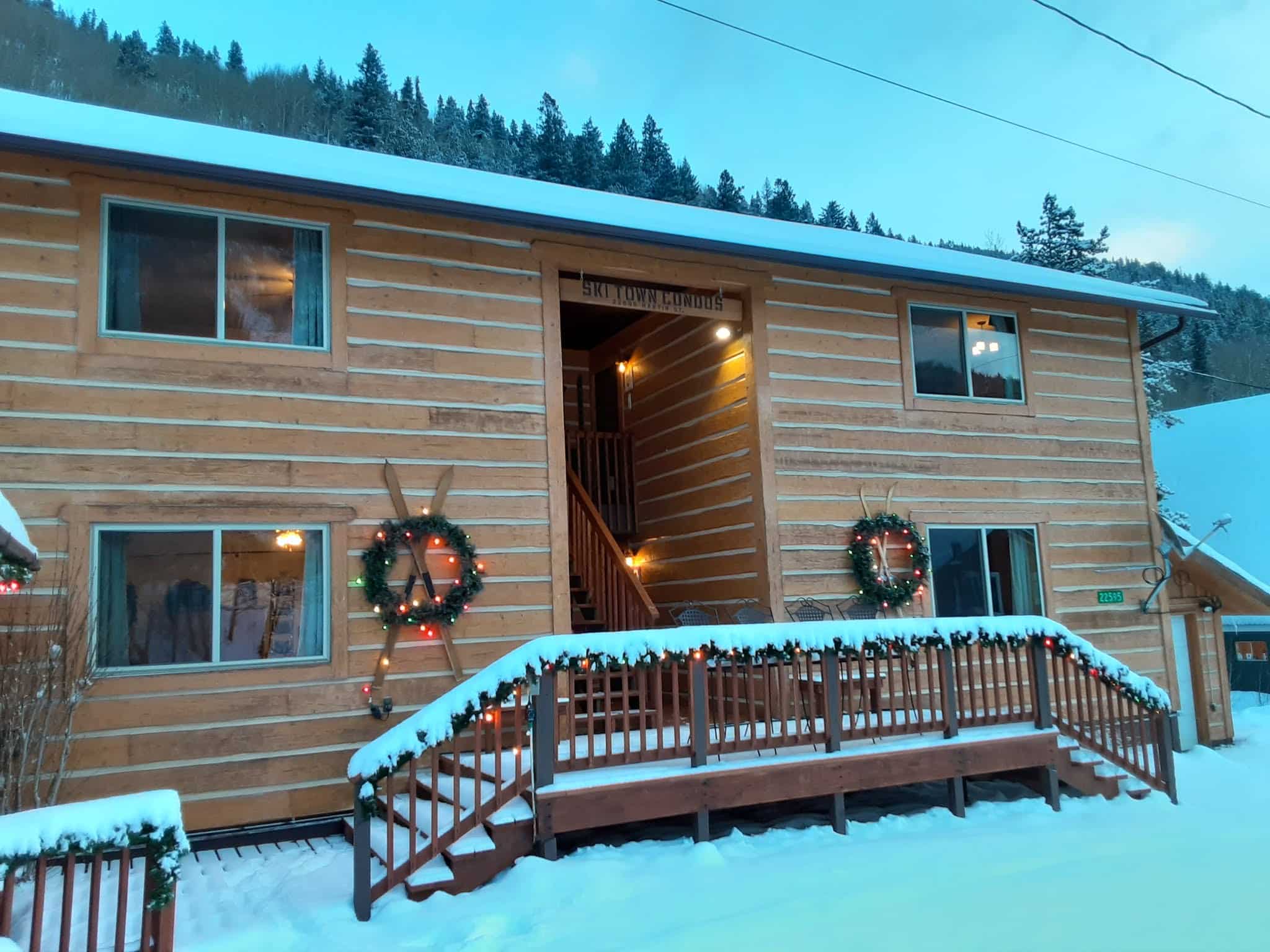 Exterior mountain lodge with garland and Christmas wreaths.