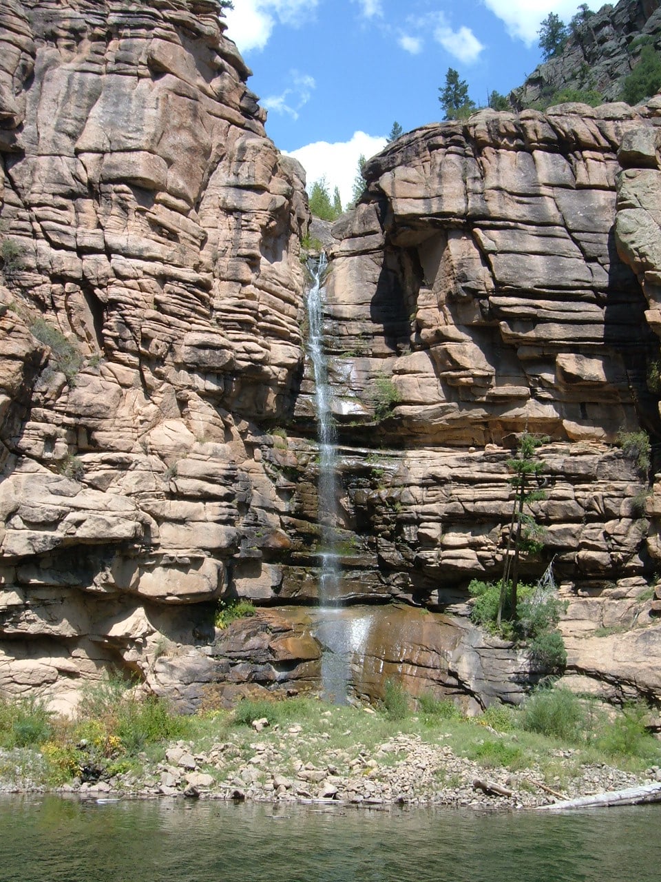 Outdoor waterfall in the rocky mountians on a sunny day.