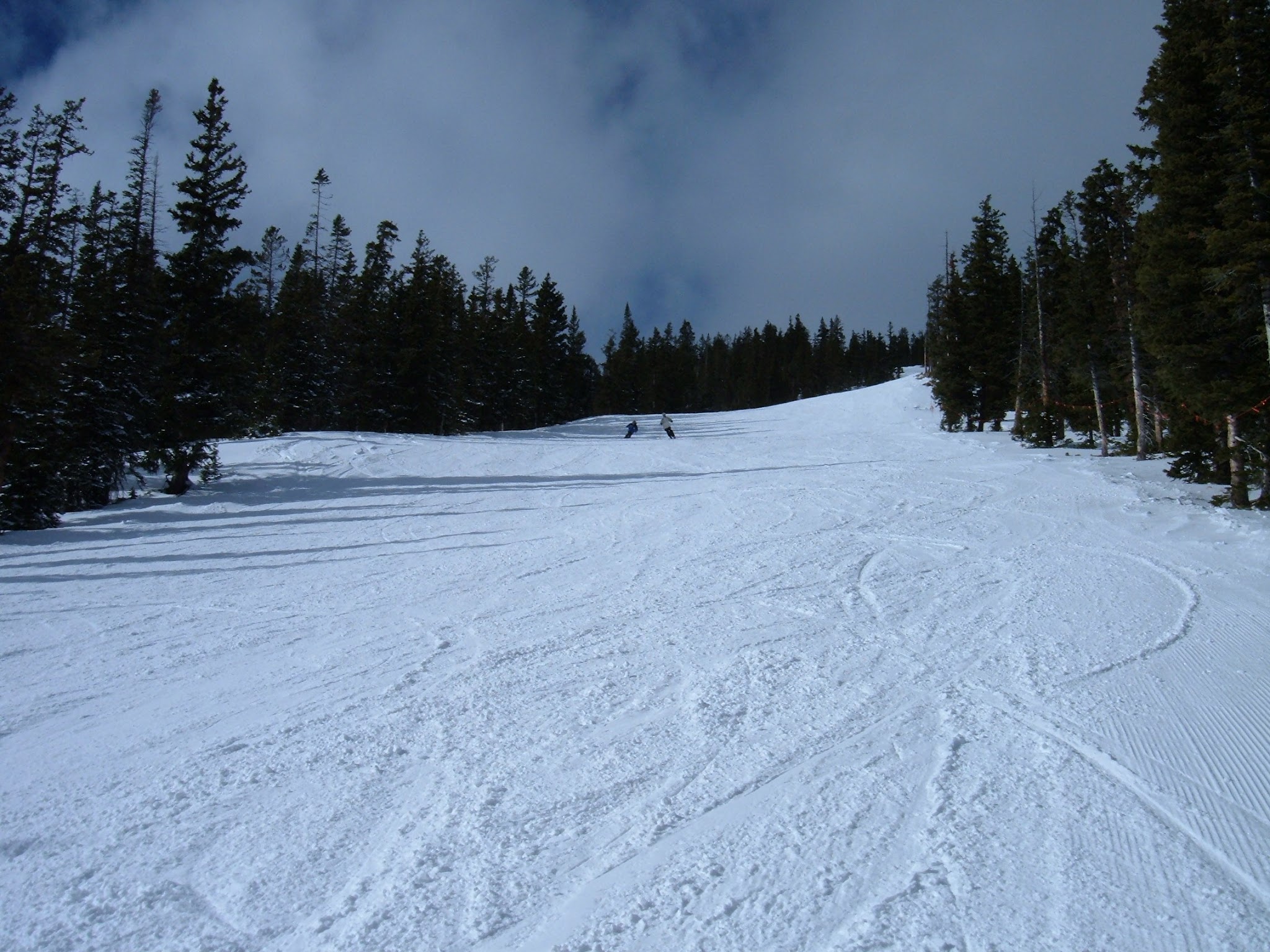 Groomed trail at a ski area on a sunny day.