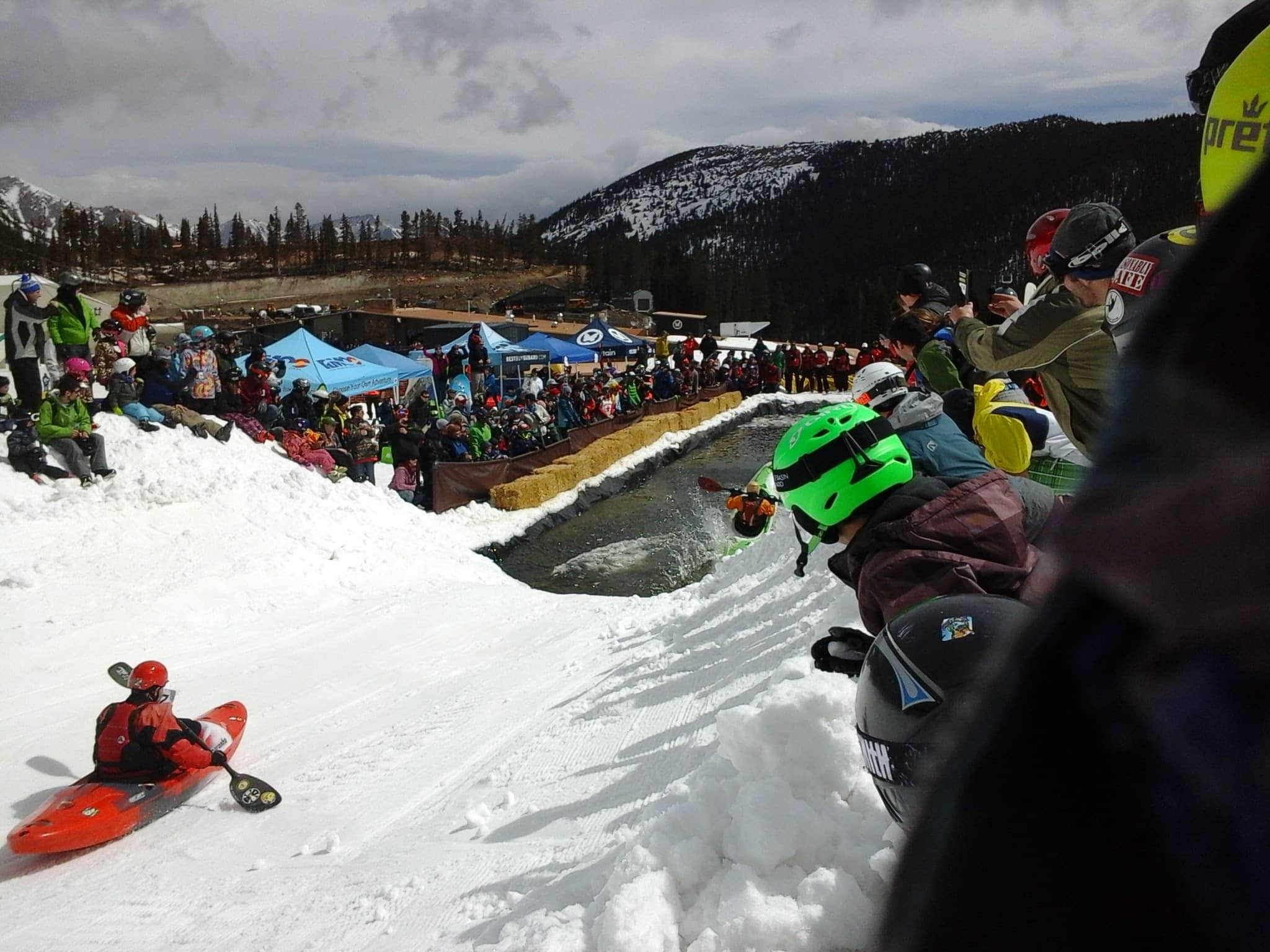 Kayaks on Snow on a ski mountain with people cheering them on.