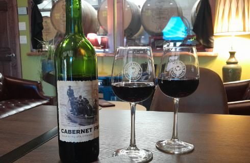 Close up view of a wine bottle and wine glasses filled with red wine