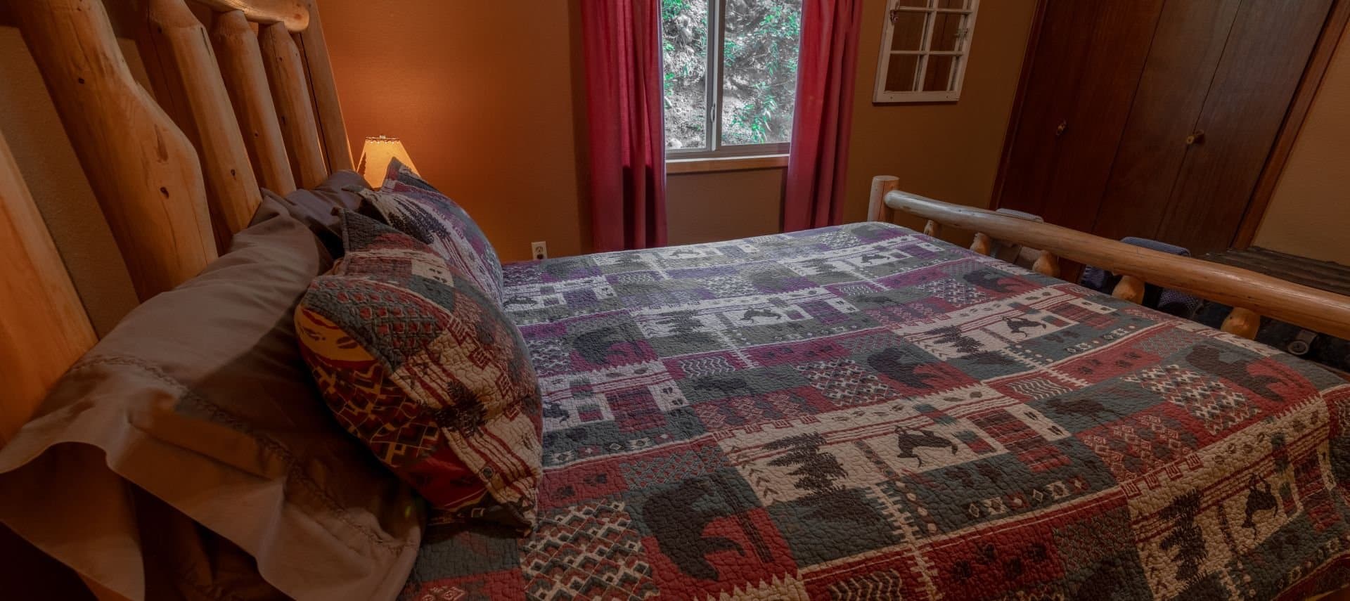 Log bed with a lodge quilt, brown walls.