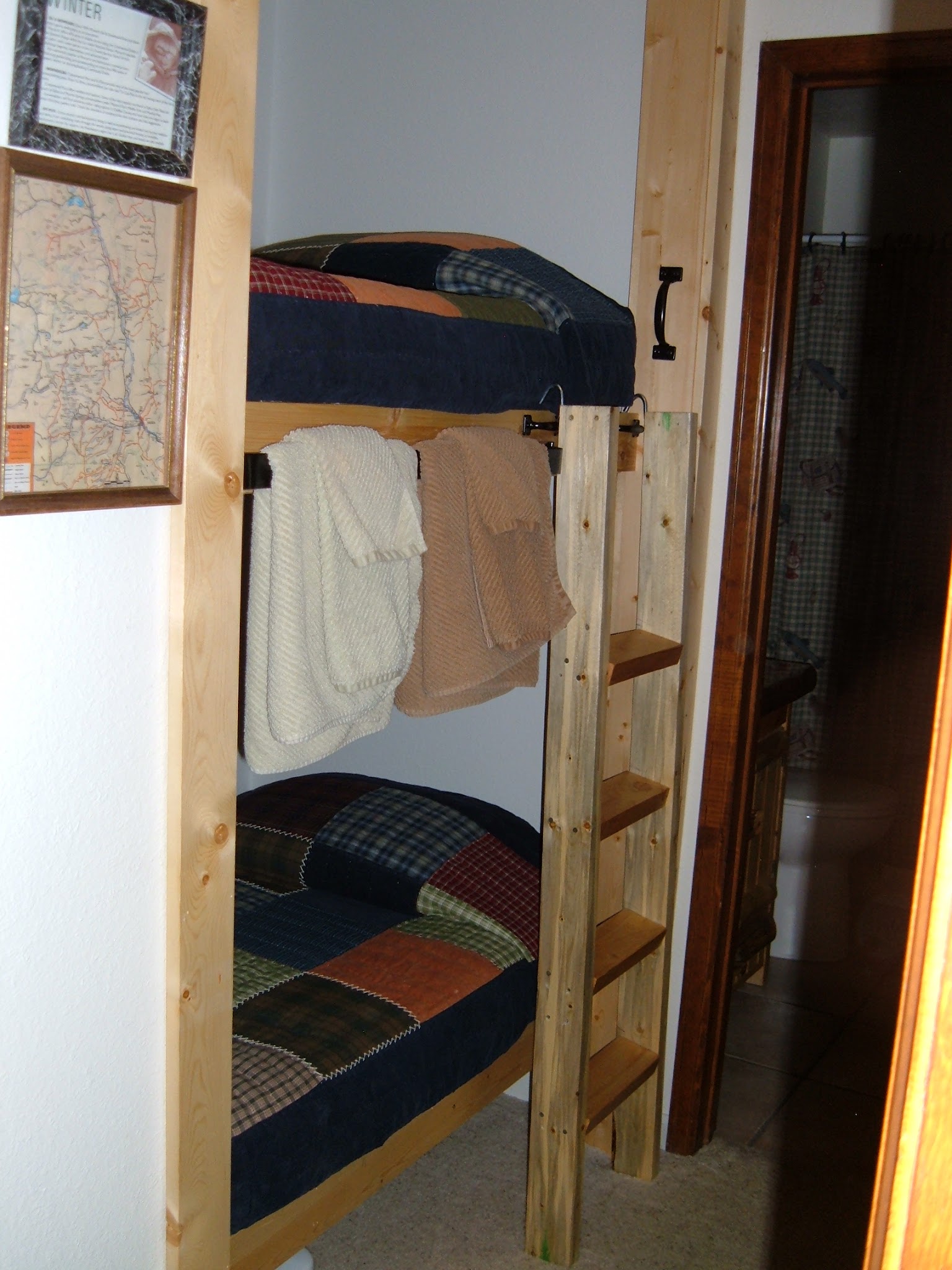 Built in bunk beds in a hallway leading to a bathroom.