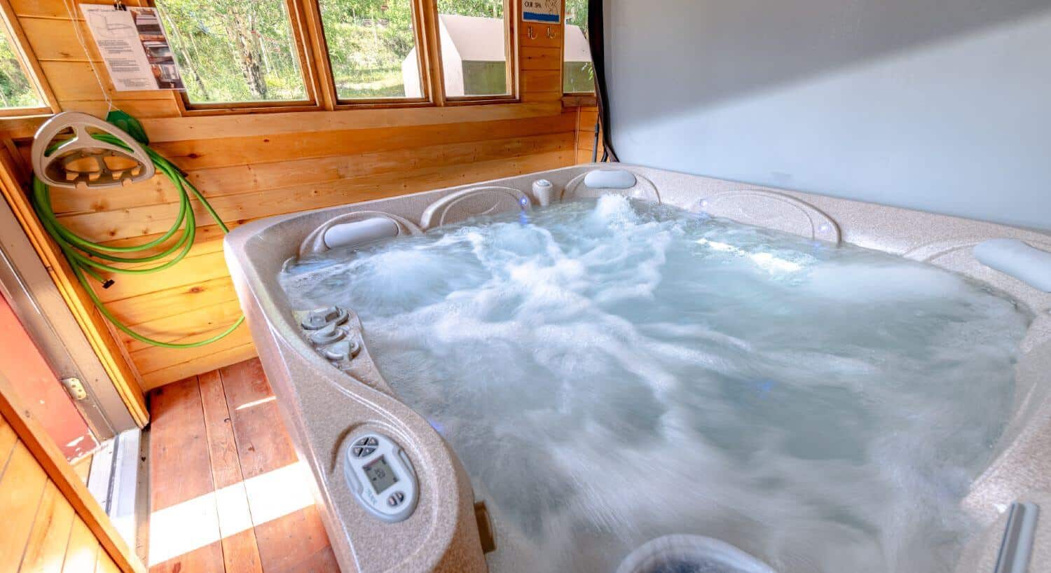 Bubbling hot tub in a gazebo with windows.