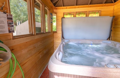 Wooden building housing a hot tub with bubbling water