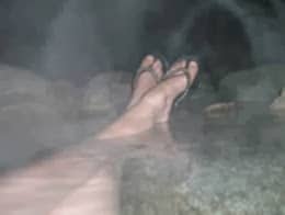 Feet soaking in a creek pool of natural hot springs.